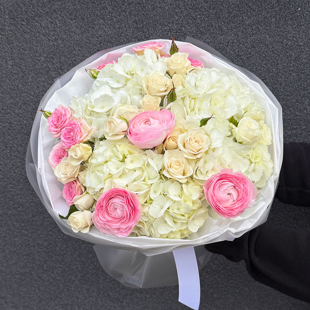 Bukiet z różowego ranunculusa, białej hortensji i róży gałązkowej