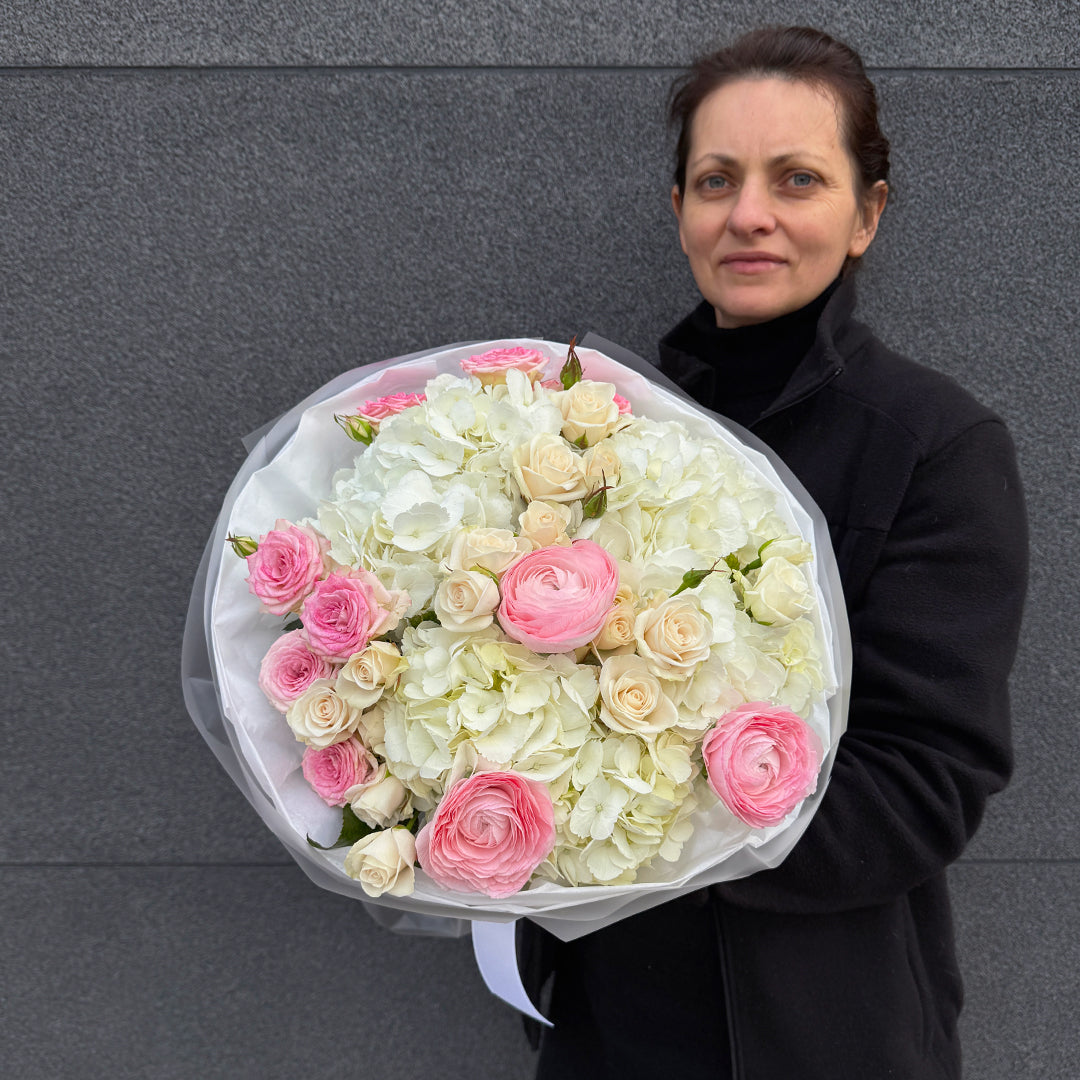 Bukiet z różowego ranunculusa, białej hortensji i róży gałązkowej