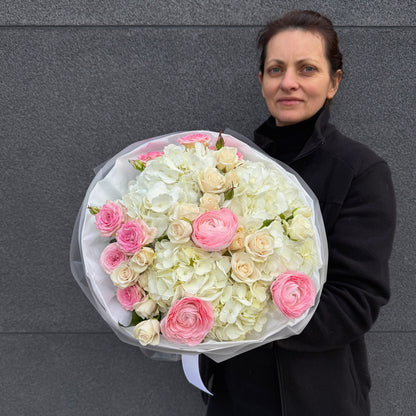 Bukiet z różowego ranunculusa, białej hortensji i róży gałązkowej