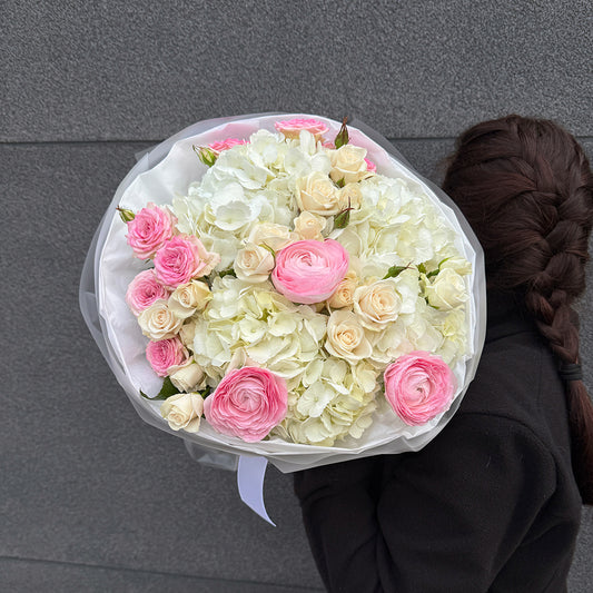 Bukiet z różowego ranunculusa, białej hortensji i róży gałązkowej